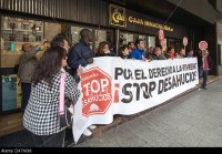 An affected’s group of eviction by spanish banks protest in front of bank claim with a banner in Saragossa, Spain